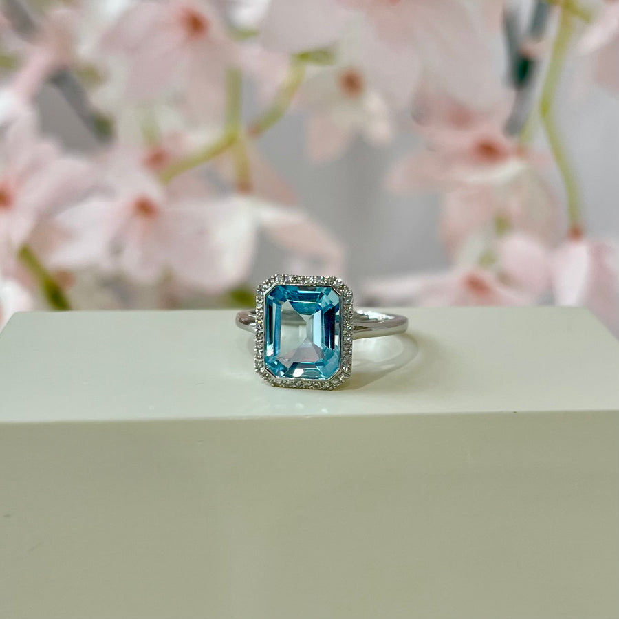 Emerald Cut Blue Topaz & Diamond Halo Ring in 9ct White Gold
